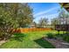 A fenced backyard features a manicured lawn and mature trees and landscaping at 11715 W 30Th Pl, Lakewood, CO 80215