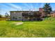 Expansive backyard featuring a two-story deck, lush lawn, and mature landscaping for outdoor enjoyment at 11715 W 30Th Pl, Lakewood, CO 80215