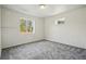 The bedroom has neutral carpeting, two windows, and white walls and trim at 11715 W 30Th Pl, Lakewood, CO 80215
