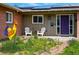 Charming front porch with white chairs, a colorful rooster statue, and a vibrant purple front door at 11715 W 30Th Pl, Lakewood, CO 80215
