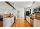 Modern kitchen with stainless steel appliances, white cabinetry, and hardwood floors throughout at 11715 W 30Th Pl, Lakewood, CO 80215