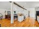 Bright kitchen featuring an island with breakfast bar, wooden beam, modern appliances, and hardwood floors at 11715 W 30Th Pl, Lakewood, CO 80215