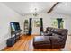 Cozy living room with a leather sofa, hardwood floors, a beamed ceiling and lots of natural light at 11715 W 30Th Pl, Lakewood, CO 80215
