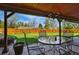 Covered outdoor patio with stylish metal chairs and glass table, offering a perfect relaxation space at 11715 W 30Th Pl, Lakewood, CO 80215