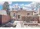 A brick house features a spacious backyard with stone walkway and numerous raised garden beds and a privacy fence at 1462 Eudora St, Denver, CO 80220