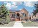 Charming brick home featuring solar panels, a brick archway, and landscaped front yard at 1462 Eudora St, Denver, CO 80220