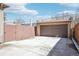 A detached garage with a brown door and concrete parking area at 1462 Eudora St, Denver, CO 80220