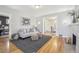 Bright living room boasts hardwood floors, gray couch, and decor, adjacent dining area and fireplace at 1462 Eudora St, Denver, CO 80220