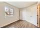 Bedroom featuring modern wood-look flooring, a large window, and a closet at 909 S Dawson Way # 2, Aurora, CO 80012