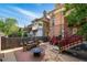 Backyard includes brick and stone patios with a fire pit, dining table, chairs, and red stairs at 1438 N Franklin St # 100, Denver, CO 80218