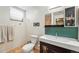 Bathroom featuring sleek vanity with modern fixtures, decorative tile accents, and a commode at 1438 N Franklin St # 100, Denver, CO 80218