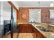 Beautiful kitchen with granite countertops, exposed brick, and stainless appliances at 1438 N Franklin St # 100, Denver, CO 80218