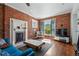 Cozy living room featuring exposed brick, a fireplace, and lots of natural light at 1438 N Franklin St # 100, Denver, CO 80218