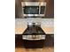 Modern stainless steel stove and microwave, complemented by a stylish backsplash at 16841 Askins Loop # 208, Parker, CO 80134