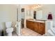 Bright bathroom featuring double sinks with a wood vanity and a tile floor at 20336 E 48Th Dr, Denver, CO 80249