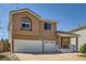 Two-story home showcasing a three-car garage and covered front porch entrance at 20336 E 48Th Dr, Denver, CO 80249