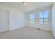 Cozy bedroom featuring two windows and neutral carpeting at 5546 Inland Ave, Firestone, CO 80504