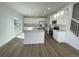 Modern kitchen featuring white cabinets, stainless steel appliances, a central island, and sliding door access to outside at 5546 Inland Ave, Firestone, CO 80504