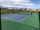 Outdoor pickleball court featuring a green surface, bench seating, and surrounded by a black chain-link fence at 5546 Inland Ave, Firestone, CO 80504