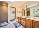Bathroom featuring a double sink vanity, large mirrors with lights, and a glass door shower at 18150 Martingale Rd, Monument, CO 80132