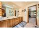Bright bathroom showcasing a double sink vanity, large mirrors, and an open doorway at 18150 Martingale Rd, Monument, CO 80132