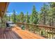 Inviting wooden deck with outdoor seating and stunning views of the surrounding evergreen forest at 18150 Martingale Rd, Monument, CO 80132