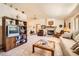 Cozy living room with a stone fireplace, ceiling fan, and neutral carpet at 18150 Martingale Rd, Monument, CO 80132