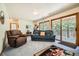 Cozy living room with a leather recliner, sofa, and sliding glass doors to the outside patio at 18150 Martingale Rd, Monument, CO 80132