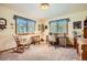 Office space featuring a desk, chair, rocking chair, and two windows with natural light at 18150 Martingale Rd, Monument, CO 80132