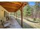 Covered patio with ample seating, perfect for enjoying the serene wooded surroundings at 18150 Martingale Rd, Monument, CO 80132