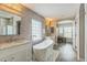 Modern bathroom showcasing a soaking tub, dual sink vanity, walk-in shower, and mosaic tile floor at 14223 Piney River Rd, Broomfield, CO 80023