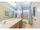 Bathroom featuring double sinks with wood cabinets and a shower-tub combination at 14223 Piney River Rd, Broomfield, CO 80023