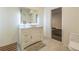 Bright bathroom featuring a white vanity, tile flooring, and an open doorway at 14223 Piney River Rd, Broomfield, CO 80023