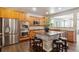 Modern kitchen featuring stainless steel appliances, a central island with seating, and hardwood floors at 14223 Piney River Rd, Broomfield, CO 80023