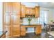Bright kitchen with custom cabinets, desk area, stone backsplash, and a view to the breakfast nook at 14223 Piney River Rd, Broomfield, CO 80023