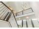 Elegant staircase with iron railings, modern chandelier and high ceilings, creating a grand entrance at 14223 Piney River Rd, Broomfield, CO 80023