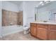 Bathroom featuring tile surround bathtub, tile flooring, and light wood vanity at 2705 S Danube Way # 110, Aurora, CO 80013