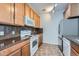 Functional kitchen featuring wooden cabinets, stone countertops, and essential appliances at 2705 S Danube Way # 110, Aurora, CO 80013