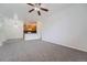Spacious living room featuring neutral carpet, ceiling fan, and open layout to the kitchen at 2705 S Danube Way # 110, Aurora, CO 80013