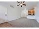 Bright living room with a ceiling fan, carpet, an open floor plan, and a white front door at 2705 S Danube Way # 110, Aurora, CO 80013