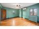 Bedroom featuring hardwood floors, two windows, a ceiling fan, and neutral wall paint at 2646 Colorado Blvd, Denver, CO 80207