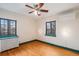 Bright bedroom featuring hardwood floors, updated windows, and a modern ceiling fan at 2646 Colorado Blvd, Denver, CO 80207
