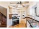 Cozy kitchen featuring stainless steel oven, painted cabinetry and checkered tile backsplash at 2646 Colorado Blvd, Denver, CO 80207