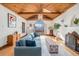 Inviting living room featuring wood ceilings, fireplace and large window at 2646 Colorado Blvd, Denver, CO 80207