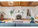Inviting living room featuring a fireplace, hardwood floors, and a distinctive wood-paneled ceiling at 2646 Colorado Blvd, Denver, CO 80207