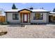 Charming one-story home with a minimalist rock yard, red door, and natural wood entry covering at 5362 S Cedar St, Littleton, CO 80120