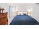 Bedroom featuring a bed with a blue quilt, side tables, and a wooden dresser at 1557 Fillmore St, Denver, CO 80206