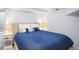 Bedroom featuring a bed with a blue quilt, side tables, and lamps at 1557 Fillmore St, Denver, CO 80206