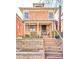Classic two-story brick home with a welcoming front porch and raised garden bed at 1557 Fillmore St, Denver, CO 80206