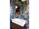 Stylish powder room with patterned wallpaper, modern sink, and custom mirror at 1557 Fillmore St, Denver, CO 80206